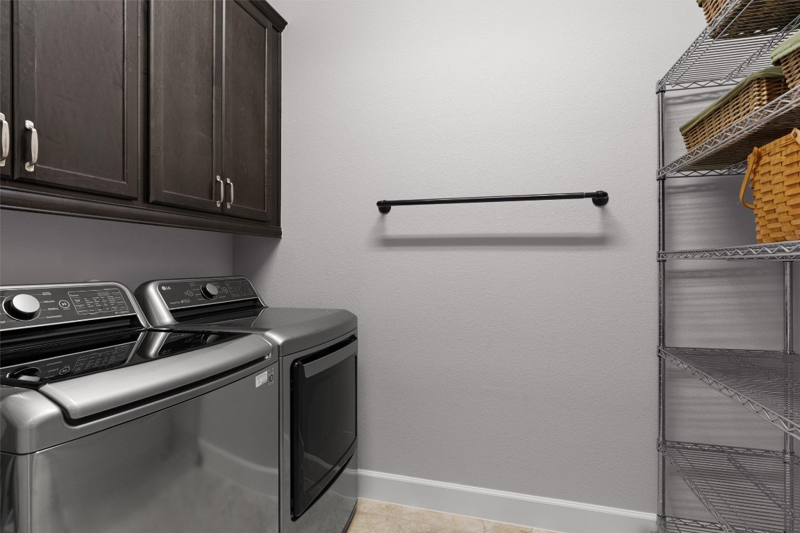 313 Racing Oak Loop San Marcos, TX 78666 - Photo 28 of 39 Off the hallway is the laundry room which is accessed by a barn door, Cabinets over the washer/dryer plus storage on the opposite wall. The washer/dryer stay with the home
