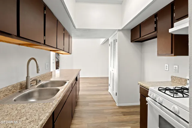 a kitchen with granite countertop a sink and a stove top oven