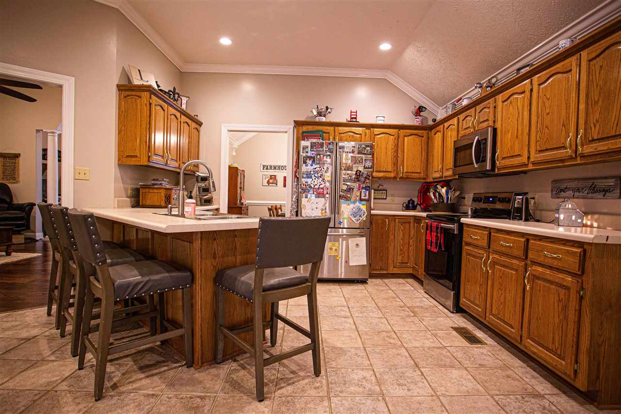 280 Church Street Ripley, TN 38063 - Photo 8 of 25 a kitchen with stainless steel appliances kitchen island granite countertop a sink table and chairs
