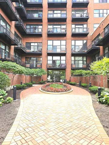a front view of a building with a garden and plants