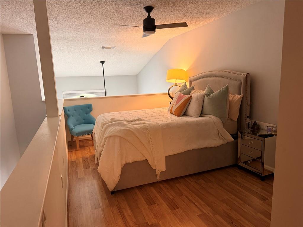 3655 Habersham Road Northeast, Unit 303 Atlanta, GA 30305 - Photo 6 of 9 a bedroom with a bed and wooden floor