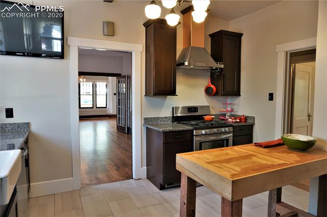 320 West Cheyenne Road Colorado Springs, CO 80906 - Photo 11 of 18 The gas range and coppertone vent hood are classic touches for this modern kitchen in a historic home, and the wall-mount TV means Food Network is just a click away without having to set your tablet or device too close to the food preparations.