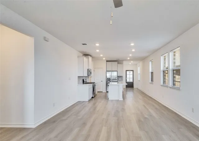 a view of kitchen with stainless steel appliances refrigerator oven and cabinets
