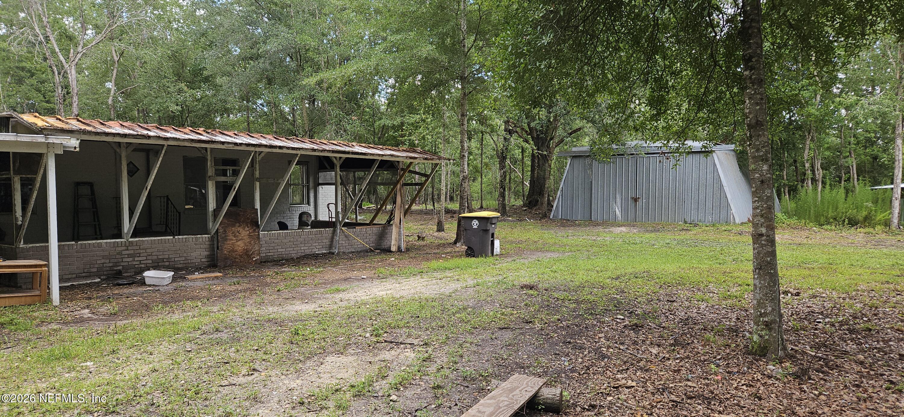 5363 Kilcrease Road Jacksonville, FL 32234 - Photo 3 of 29 a view of a backyard with large trees and wooden fence