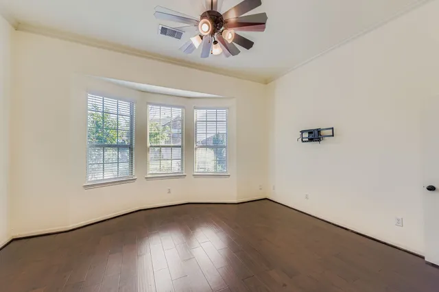 wooden floor in an empty room with a window