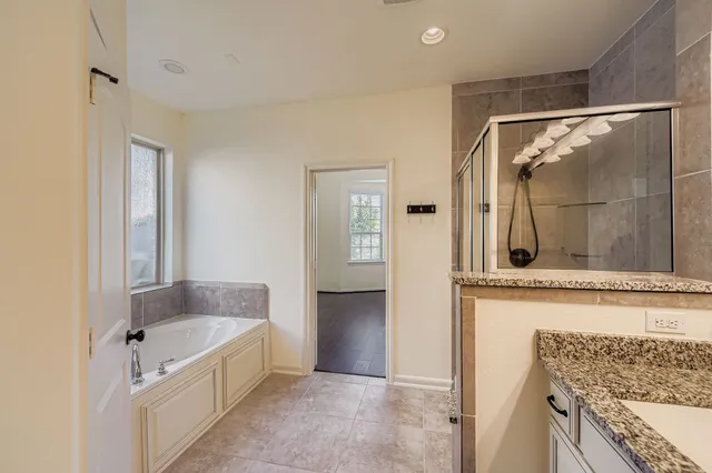 a bathroom with a tub mirror and sink