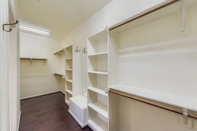 a view of walk in closet with empty racks