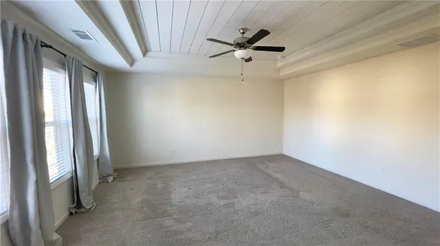 an empty room with a ceiling fan and window