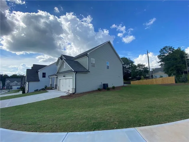 a view of a house with a big yard and a large tree