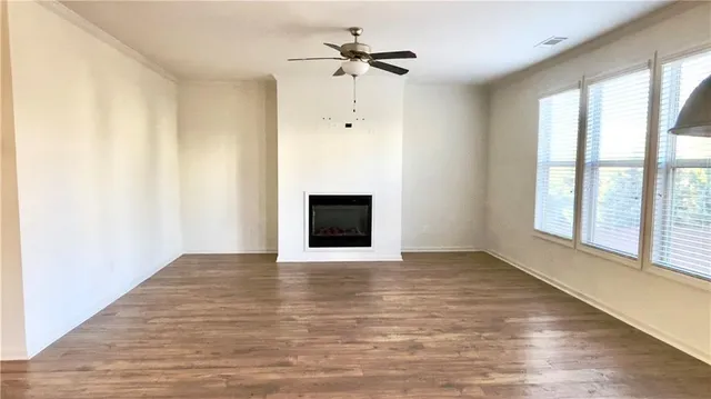 a view of an empty room with a window and a fireplace