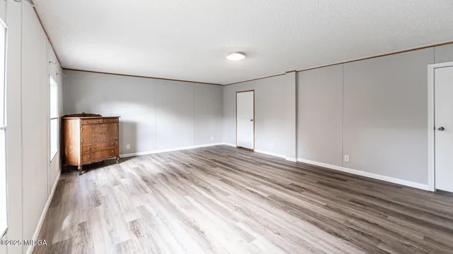 a view of empty room with wooden floor