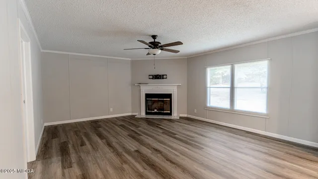 a view of an empty room with a fireplace and a window