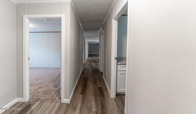 a view of a hallway with wooden floor and staircase