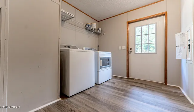 a utility room with wooden floor washer and dryer