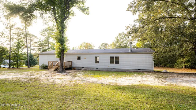 a view of a house with a big yard and large tree