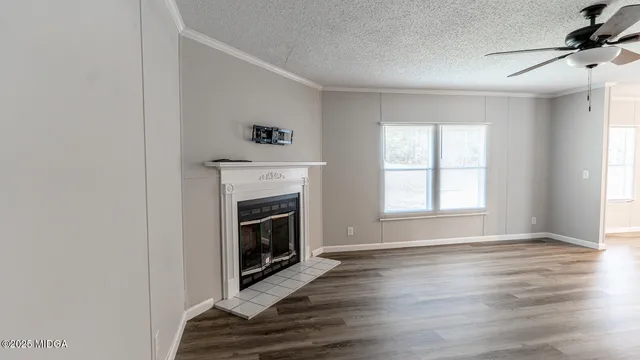 a view of empty room with fireplace and wooden floor