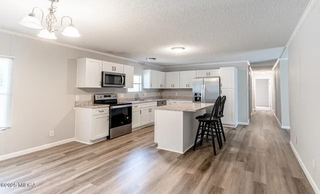 a kitchen with a table chairs microwave and cabinets