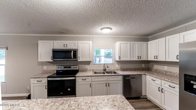 a kitchen with granite countertop a stove top oven sink and cabinets