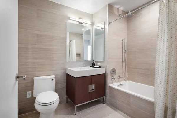 a bathroom with a granite countertop sink toilet and shower