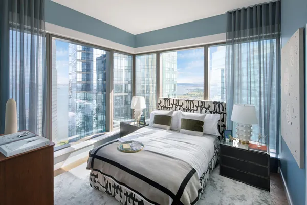 a bedroom with a bed and a large window