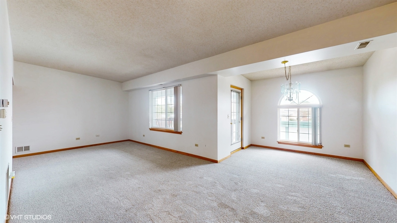 2851 West Heritage Drive, Unit 2C Joliet, IL 60435 - Photo 4 of 23 an empty room with windows and chandelier