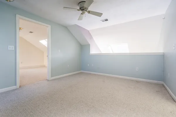 an empty room with a window and ceiling fan
