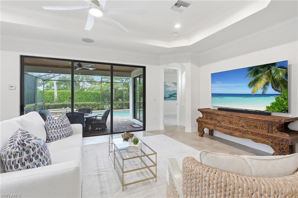 9479 Piacere Way Naples, FL 34113 - Photo 5 of 48 Tray ceiling, recessed lighting, ceiling fan, tile flooring, and sliding glass doors to outdoor living space