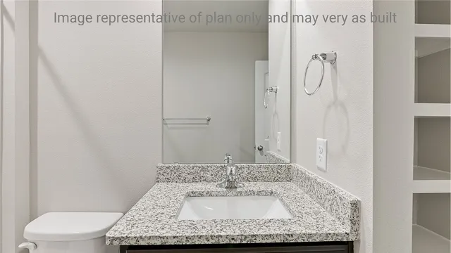 a bathroom with a granite countertop sink a toilet and a shower