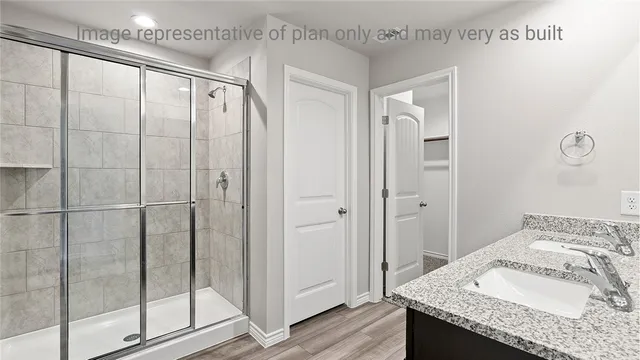 a bathroom with a granite countertop sink and shower