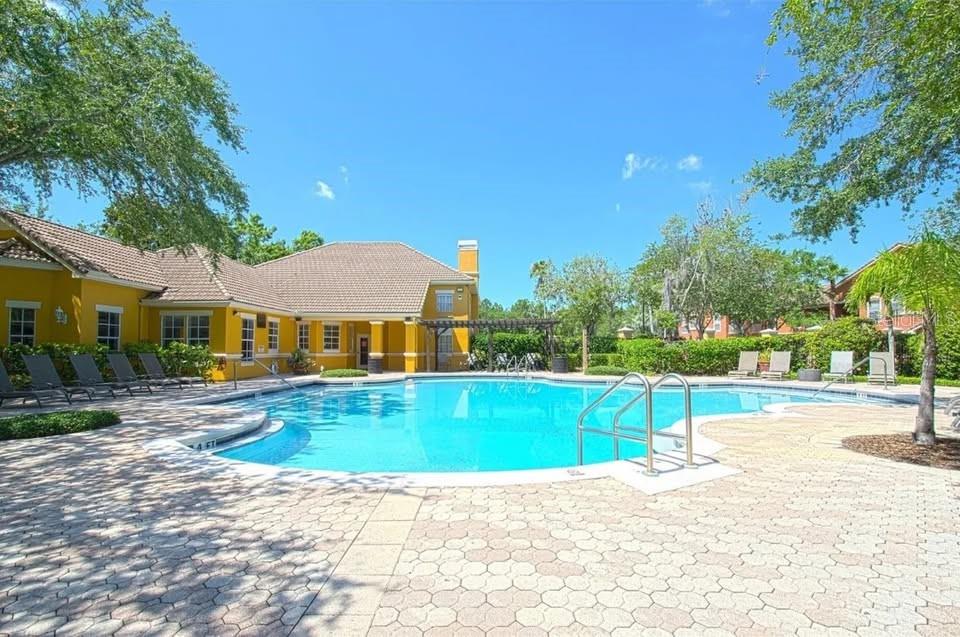 8848 Villa View Circle, Unit 206 Orlando, FL 32821 - Photo 18 of 20 a view of pool with lawn chairs and plants