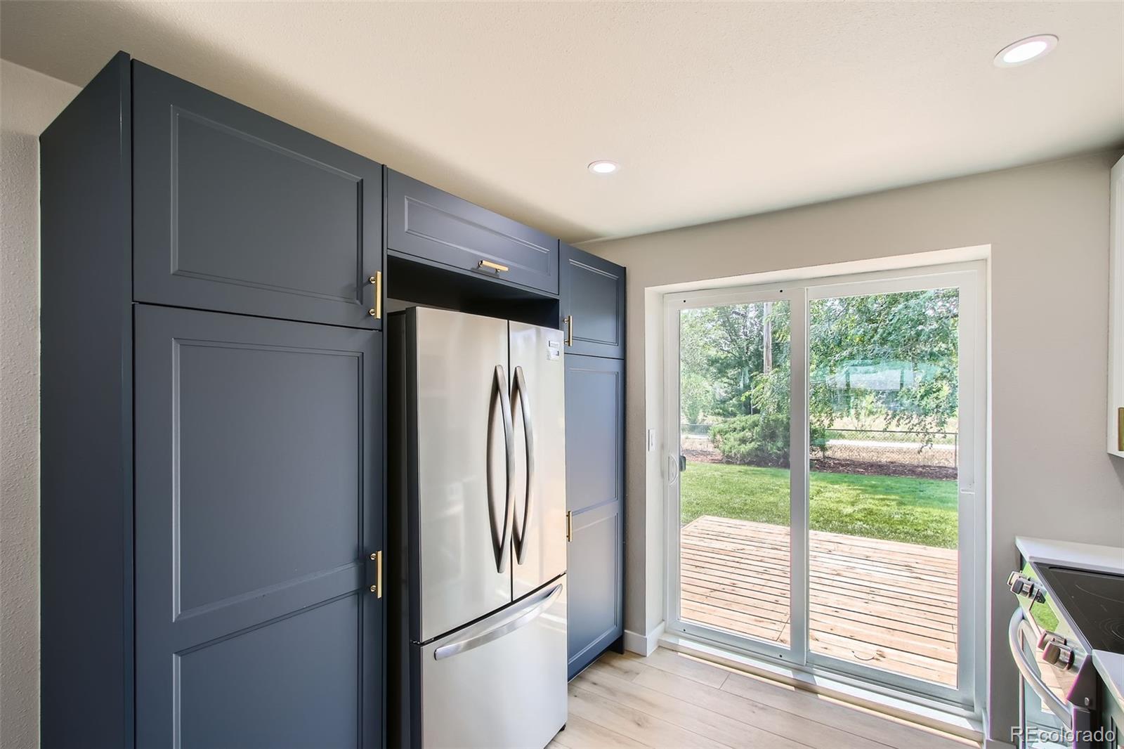 8530 West 46th Avenue Wheat Ridge, CO 80033 - Photo 5 of 20 a view of a refrigerator in kitchen and wooden floor