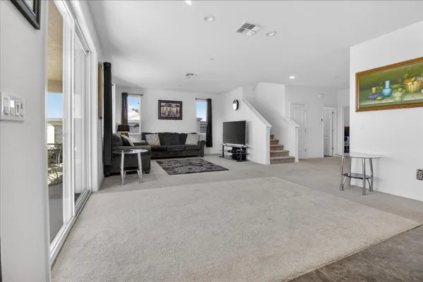 a open kitchen with stainless steel appliances granite countertop a stove top oven a sink dishwasher a dining table and chairs