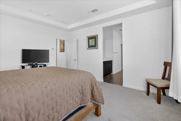 a bedroom with a bed tv and a window