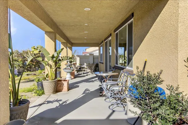 a view of a patio with table and chairs potted plants