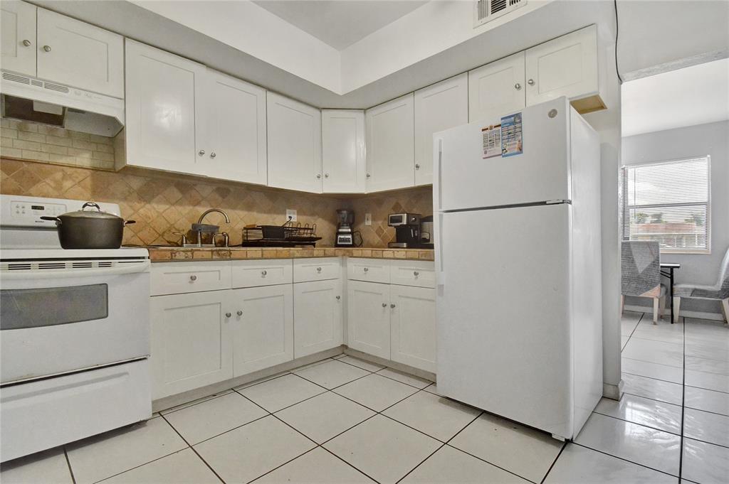 6533 Southwest 22nd Street Miramar, FL 33023 - Photo 6 of 16 a kitchen with white cabinets and white appliances