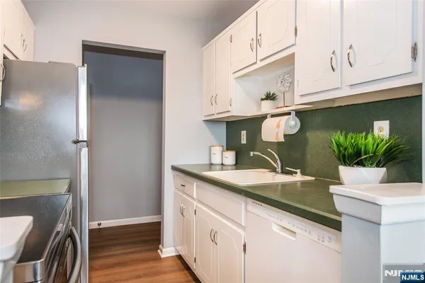 a kitchen with stainless steel appliances white cabinets and a granite counter tops
