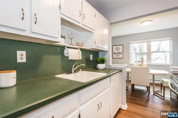 a kitchen with a sink cabinets and wooden floor