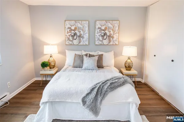 a bedroom with a bed and painting on the wall