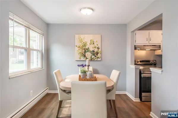 a view of a dining room with furniture a chandelier and wooden floor
