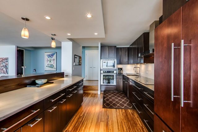 5733 North Sheridan Road, Unit 16B Chicago, IL 60660 - Photo 13 of 27 a kitchen with stainless steel appliances granite countertop a refrigerator a sink and wooden cabinets