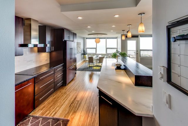 5733 North Sheridan Road, Unit 16B Chicago, IL 60660 - Photo 14 of 27 a living room with stainless steel appliances kitchen island granite countertop a refrigerator a stove and a sink with wooden floor
