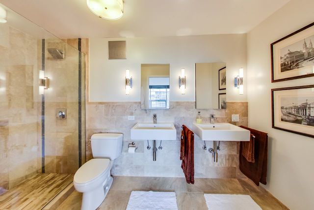 5733 North Sheridan Road, Unit 16B Chicago, IL 60660 - Photo 17 of 27 a spacious bathroom with a sink double vanity and a mirror