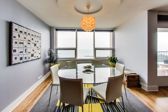 5733 North Sheridan Road, Unit 16B Chicago, IL 60660 - Photo 10 of 27 a view of a dining room with furniture a chandelier and wooden floor