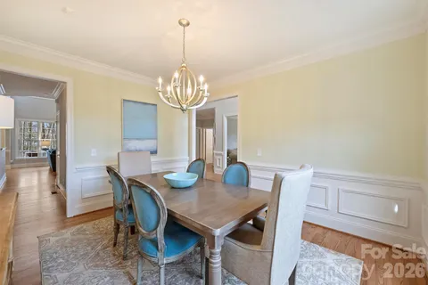 a view of a dining room with furniture a chandelier and wooden floor