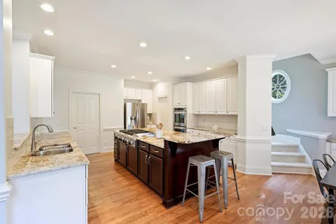 a kitchen with stainless steel appliances granite countertop a sink a stove and a refrigerator