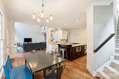 a living room with couches and kitchen view with wooden floor