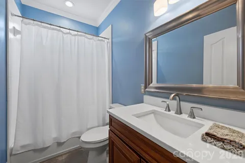 a bathroom with a granite countertop sink a toilet and a mirror