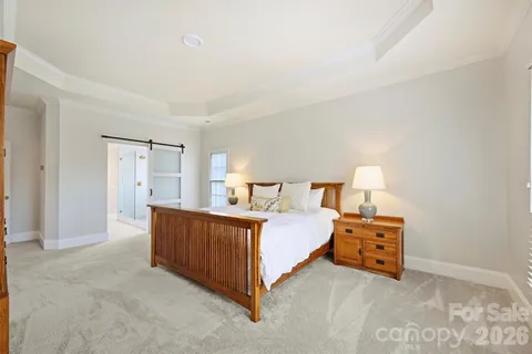 a spacious bedroom with a bed and a lamp