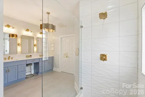 a spacious bathroom with a double vanity sink a large mirror and shower
