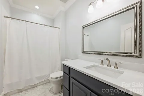 a bathroom with a granite countertop sink a toilet and a mirror